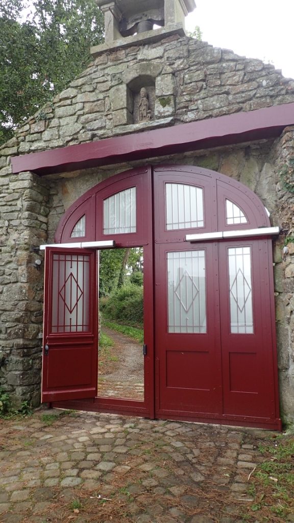 portail 2 vantaux avec ouverture électrique et portes intégrées, panneaux à table saillante au niveau des vantaux et grille au niveau des vitrages